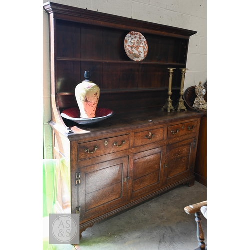 A 19th century provincial oak dresser with plate rack over three drawers and panelled cupboards on bracket feet, 164 x 44 x 183 cm high