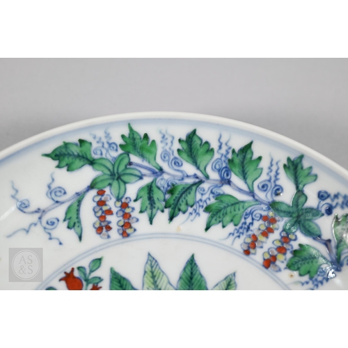 311 - A Chinese Doucai pomegranate dish, the stylised central tree surrounded by grape, peach and pomegran... 