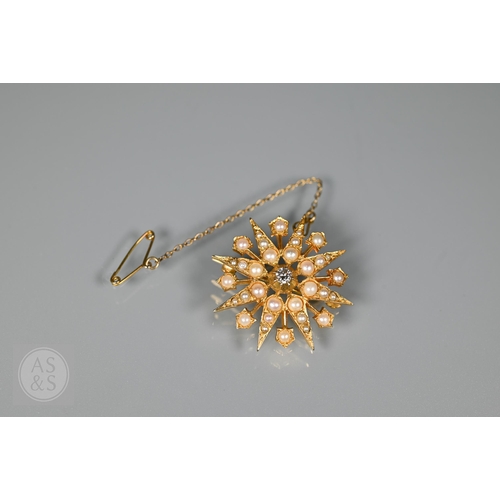 183 - A Victorian 9ct yellow gold starburst brooch set overall with seed pearls and a central old cut diam... 