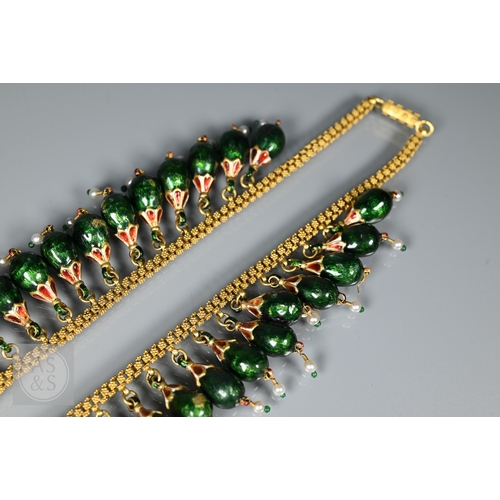 184 - An Indian fringe necklace of yellow metal chain with granulated links, suspending forty green, red a... 