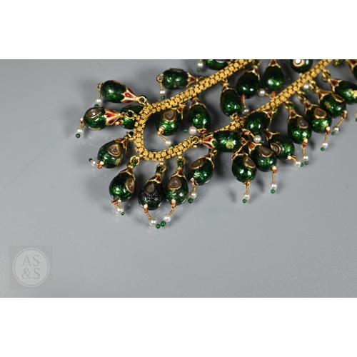 184 - An Indian fringe necklace of yellow metal chain with granulated links, suspending forty green, red a... 