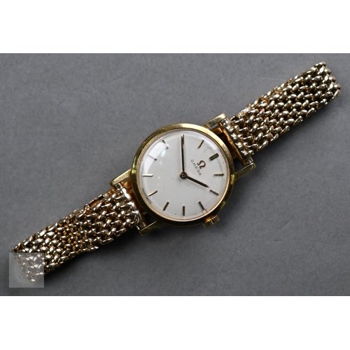 258 - A ladies 9ct gold Omega wristwatch, the 23mm case with gilt batons and hands on a champagne dial, on... 