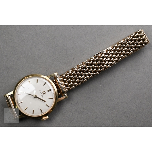 258 - A ladies 9ct gold Omega wristwatch, the 23mm case with gilt batons and hands on a champagne dial, on... 