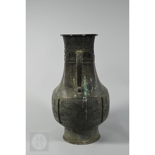 341 - A 19th century Chinese bronze twin handled vase in the form of an archaic ritual vessel, low relief ... 