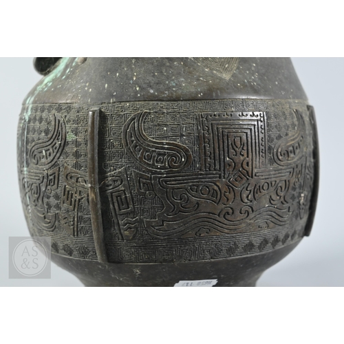 341 - A 19th century Chinese bronze twin handled vase in the form of an archaic ritual vessel, low relief ... 