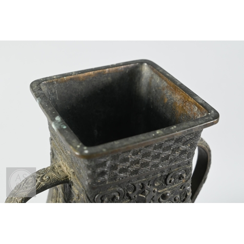 341 - A 19th century Chinese bronze twin handled vase in the form of an archaic ritual vessel, low relief ... 