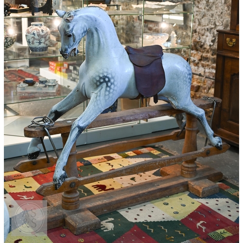 588 - An antique dapple grey painted wooden rocking horse with leather saddle, probably by FH Ayres, raise...