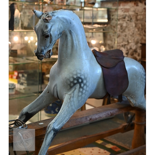 588 - An antique dapple grey painted wooden rocking horse with leather saddle, probably by FH Ayres, raise... 