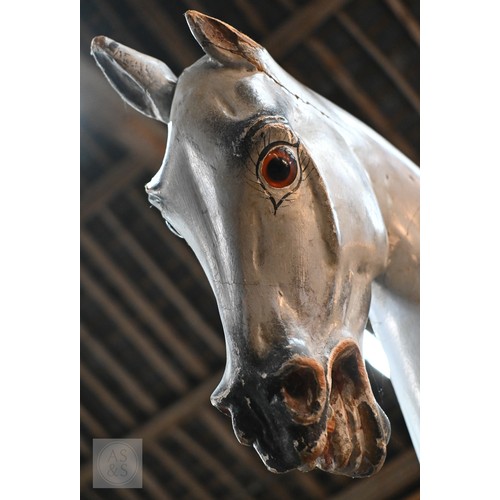 588 - An antique dapple grey painted wooden rocking horse with leather saddle, probably by FH Ayres, raise... 