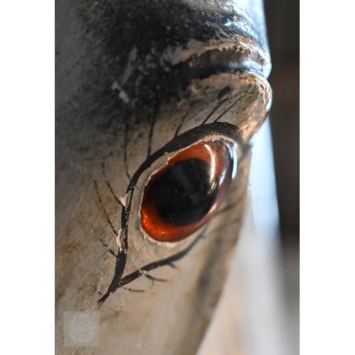 588 - An antique dapple grey painted wooden rocking horse with leather saddle, probably by FH Ayres, raise... 