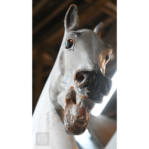 588 - An antique dapple grey painted wooden rocking horse with leather saddle, probably by FH Ayres, raise... 