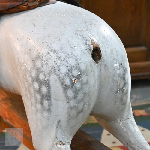 588 - An antique dapple grey painted wooden rocking horse with leather saddle, probably by FH Ayres, raise... 