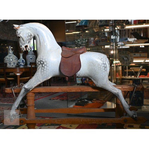 588 - An antique dapple grey painted wooden rocking horse with leather saddle, probably by FH Ayres, raise... 