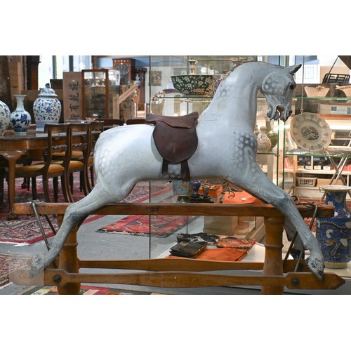 588 - An antique dapple grey painted wooden rocking horse with leather saddle, probably by FH Ayres, raise... 