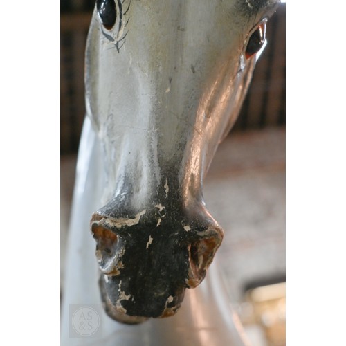 588 - An antique dapple grey painted wooden rocking horse with leather saddle, probably by FH Ayres, raise... 