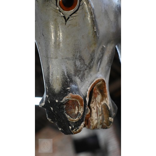 588 - An antique dapple grey painted wooden rocking horse with leather saddle, probably by FH Ayres, raise... 
