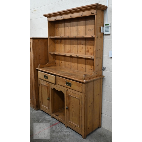 207 - A Victorian pine cottage dresser with two shelf plate rack over two drawers and panelled cupboards a... 