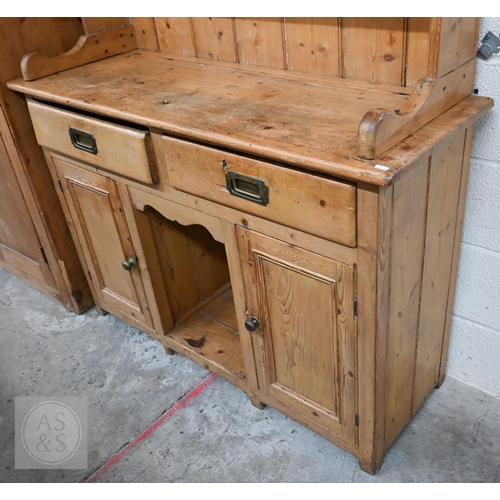 207 - A Victorian pine cottage dresser with two shelf plate rack over two drawers and panelled cupboards a... 