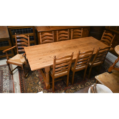 A 20th century oak refectory dining table on turned supports united by square stretchers, 216 x 90 x 74 cm high to/w a set of eight ladderback dining chairs with woven rope seats, six standard and two carvers