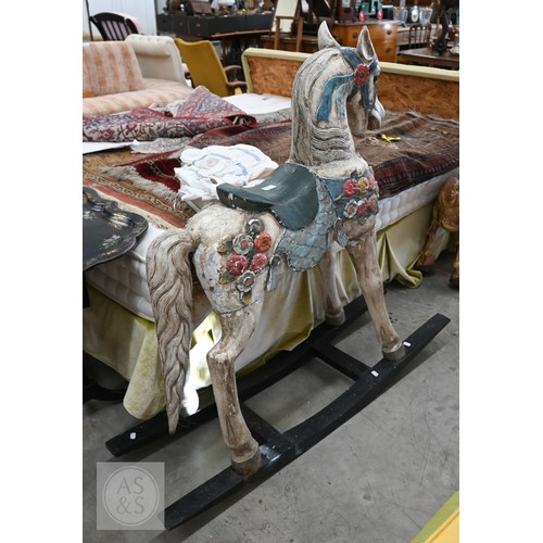 59 - A polychrome painted carved wooden rocking horse, 120 cm high