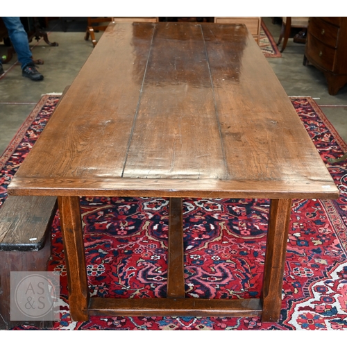 122 - An oak refectory dining table with cleated plank top on chamfered square supports united by stretche...