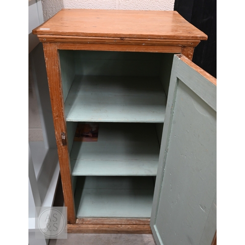 22 - An antique waxed pine panelled bedside cabinet, painted shelved interior