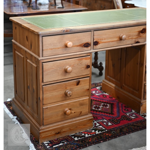 44 - A stained pine twin pedestal desk with tooled leather top and nine drawers, 140 x 60 x 82 cm high