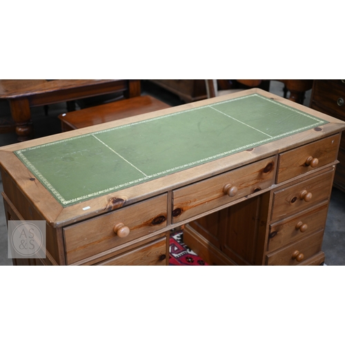 44 - A stained pine twin pedestal desk with tooled leather top and nine drawers, 140 x 60 x 82 cm high