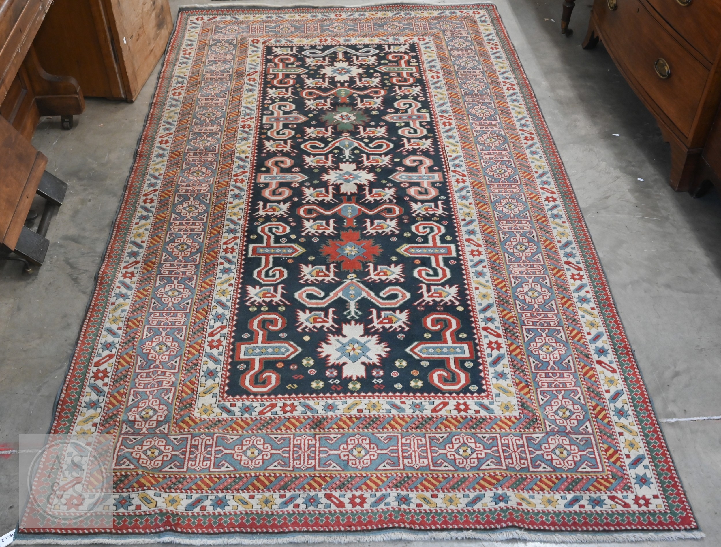 A mid-century Caucasian rug, geometric motif with latch-hooks on blue ...