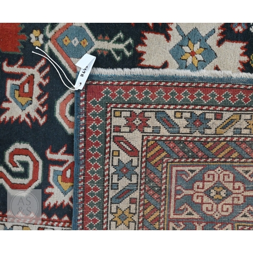 A mid-century Caucasian rug, geometric motif with latch-hooks on blue ...