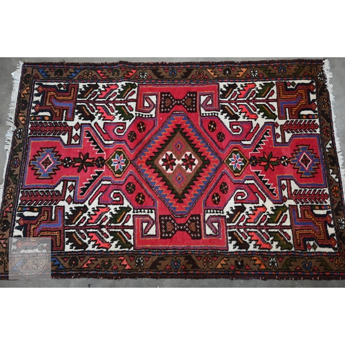 45 - A Persian Hamadan rug, of lozenge medallion design on red ground, with brown palmette and leaf borde... 