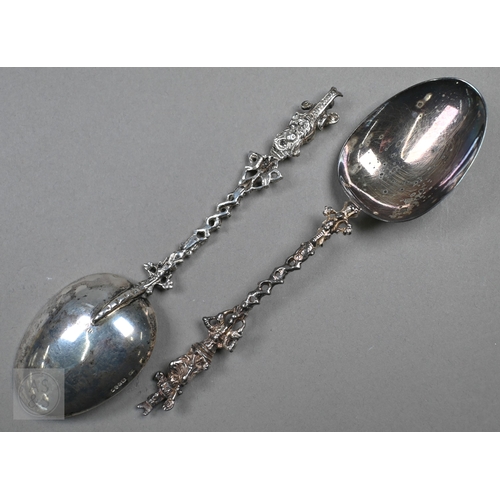 48 - A pair of Continental silver cabinet spoons, the ornate cast stems with seated figure finials, Londo... 