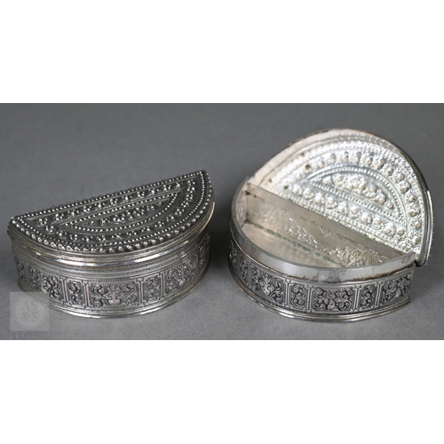 58 - A pair of Indian low-grade silver boxes oc crescent form, richly-embossed with foliage and beading, ... 