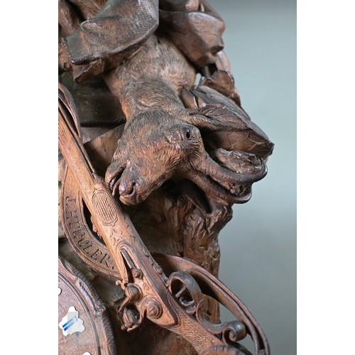 810 - J Huggler (1834-1912) a monumental carved Black Forest clock, late 19th century, carved as a seated ... 