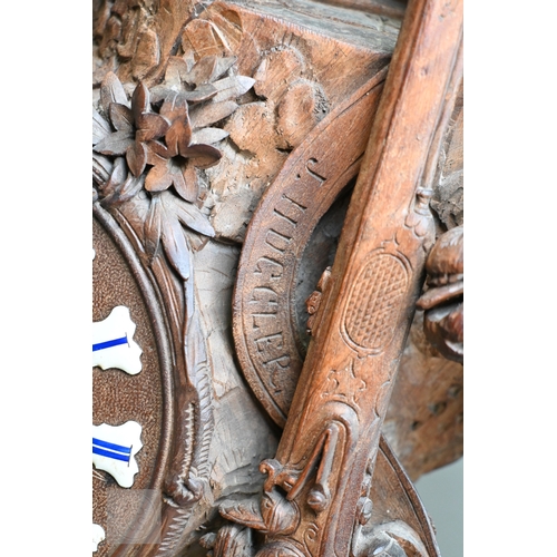 810 - J Huggler (1834-1912) a monumental carved Black Forest clock, late 19th century, carved as a seated ... 