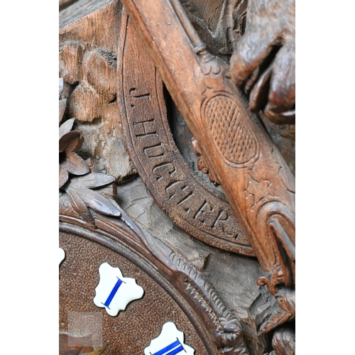 810 - J Huggler (1834-1912) a monumental carved Black Forest clock, late 19th century, carved as a seated ... 