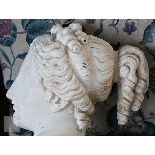 888 - An antique white marble bust of a classical female with ornate hair, on socle base, 62cm high