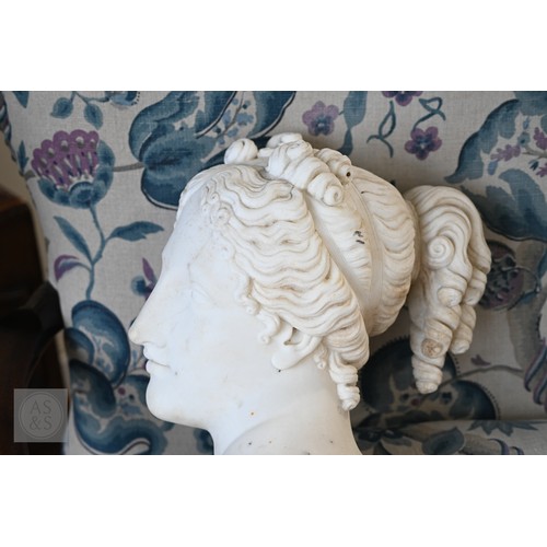 888 - An antique white marble bust of a classical female with ornate hair, on socle base, 62cm high