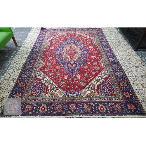 A contemporary North West Persian Tabriz carpet, the red ground centred by a blue ground medallion, 305 x 210 cm, good even pile, well balanced colours