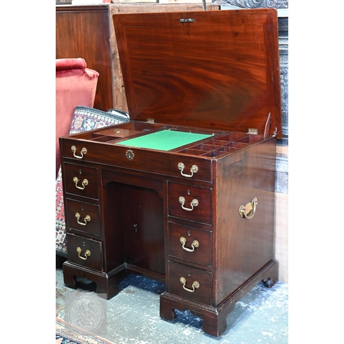 46 - A George III mahogany gentleman's dressing table/desk, the hinged top enclosing an arrangement of dr... 