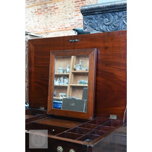 46 - A George III mahogany gentleman's dressing table/desk, the hinged top enclosing an arrangement of dr... 