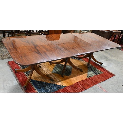 102 - A large Regency style mahogany triple pedestal extending dining table with two extra optional leaves... 