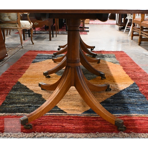 102 - A large Regency style mahogany triple pedestal extending dining table with two extra optional leaves... 