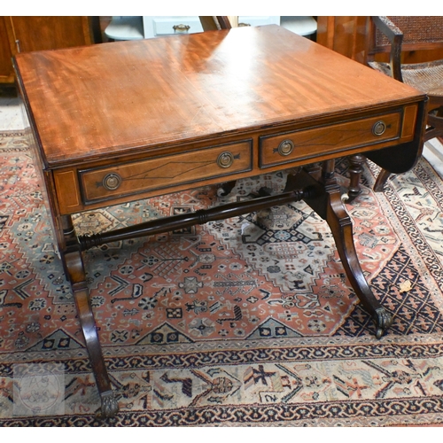 186 - A Regency style mahogany inlaid sofa table with two drawers and opposing dummy drawers on splayed le... 