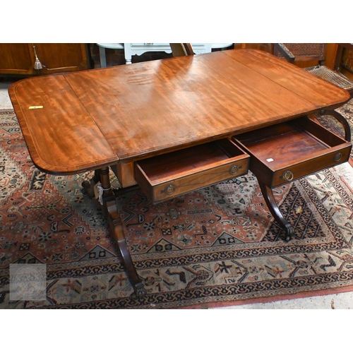 186 - A Regency style mahogany inlaid sofa table with two drawers and opposing dummy drawers on splayed le... 