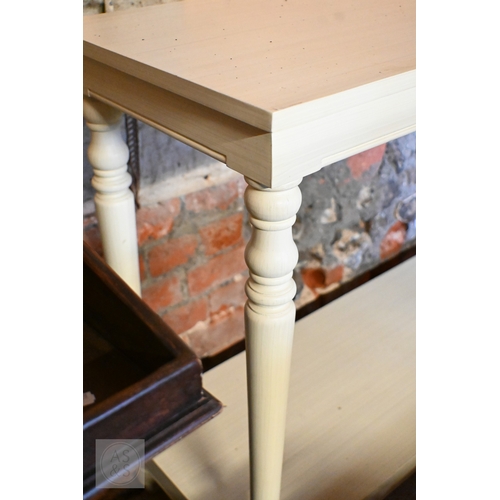 198 - A modern cream-painted two-tier console table with turned supports, 130 x 40 x 86 cm high