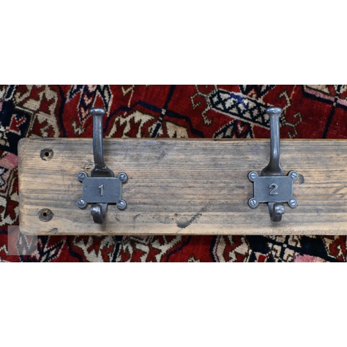 28 - A vintage style five hanger wall coat rack, the metal twin hooks numbered 1-5, 91 cm long