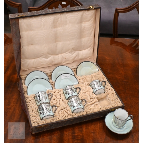 435 - A cased set of six Limoges coffee cans and saucers with silver overlays and a cased set of six Copel... 