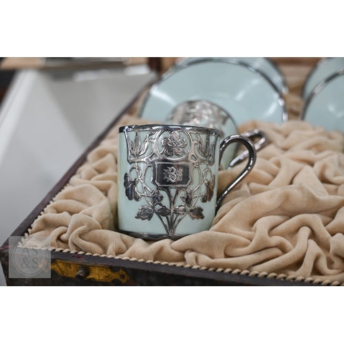 435 - A cased set of six Limoges coffee cans and saucers with silver overlays and a cased set of six Copel... 