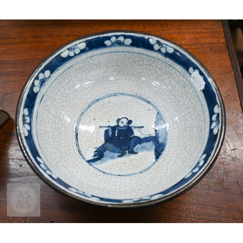 447A - A Chinese crackle-glazed bowl, painted with blue and white figures within burnt biscuit bands, 23 cm... 